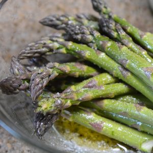 seasoning asparagus in olive oil and salt