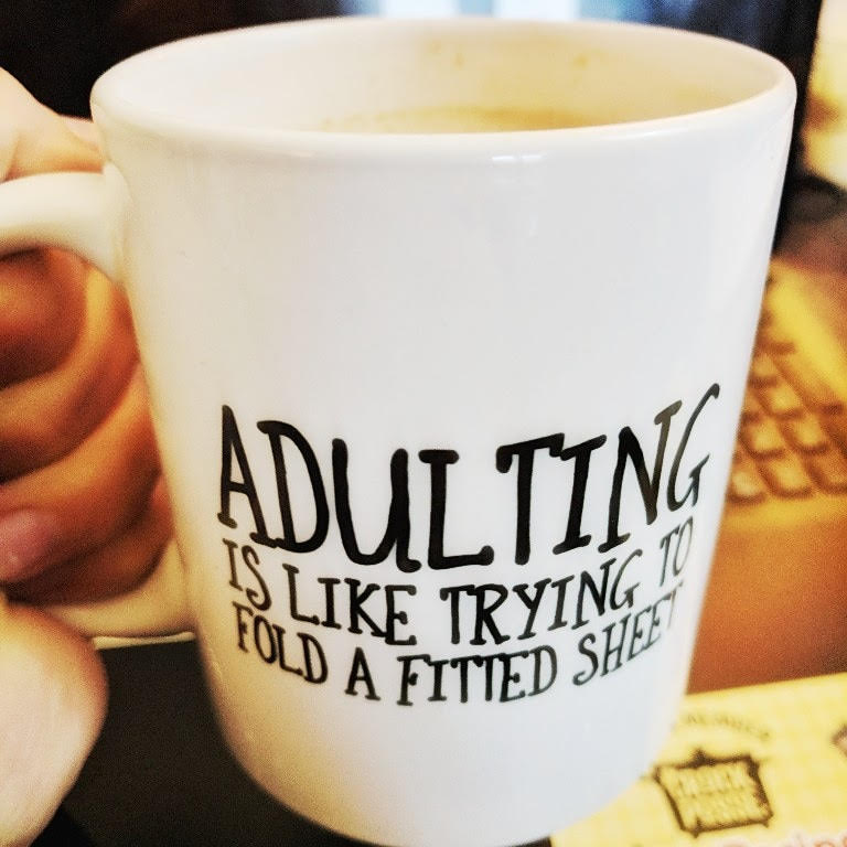 Coffee Mug that says Adulting is like trying to fold a fitted sheet.